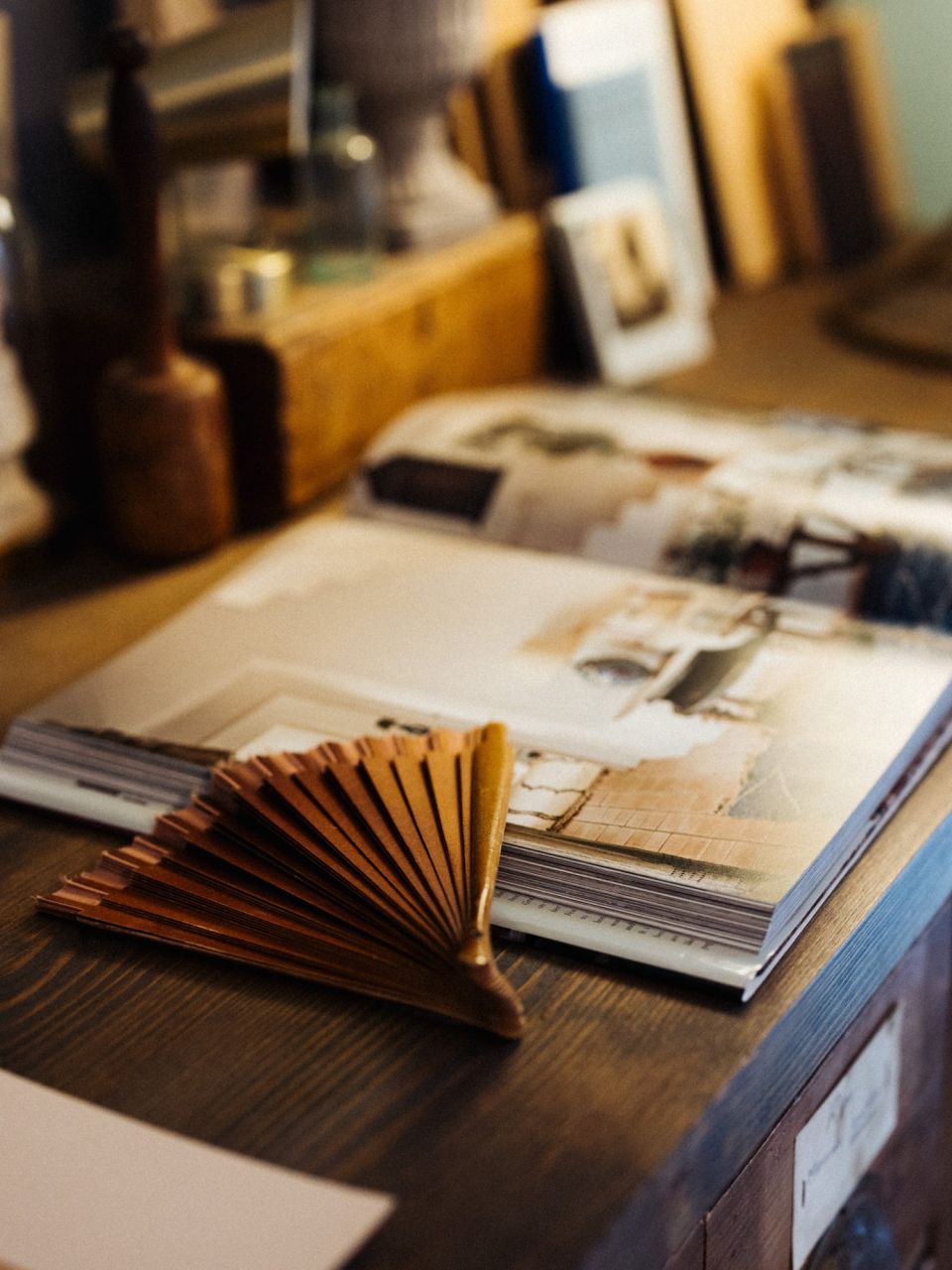 Offenes Designbuch mit einem Fächer aus Materialmustern auf einem alten Holztisch – Einblick in das kreative Wohnatelier im Schloss Arenberg.