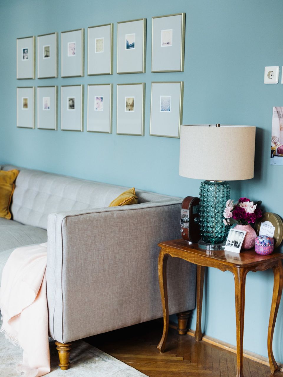 Wand in Farrow & Ball Oval Room Blue mit gerahmter Fotografie, weissem Holzstuhl, afrikanischer Maske und pinkfarbenen Blumen.